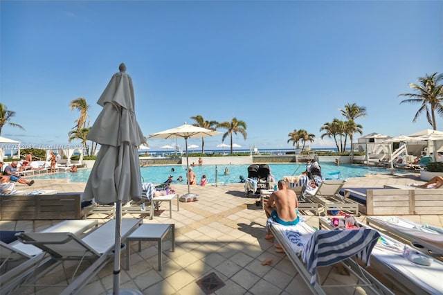 pool featuring a patio area and a water view