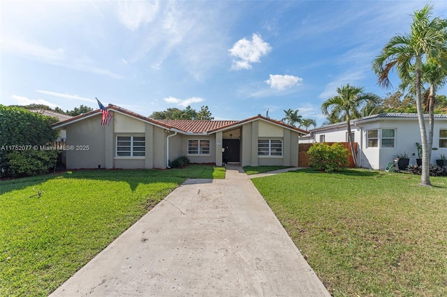 ranch-style home with a front yard, a tile roof, and stucco siding