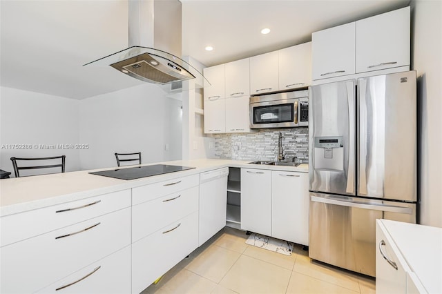 kitchen with light countertops, appliances with stainless steel finishes, white cabinets, a sink, and island range hood