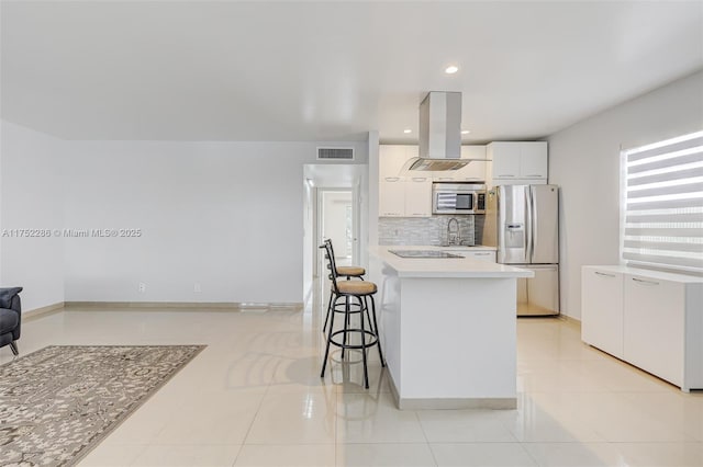 kitchen with visible vents, white cabinets, island exhaust hood, stainless steel appliances, and light countertops