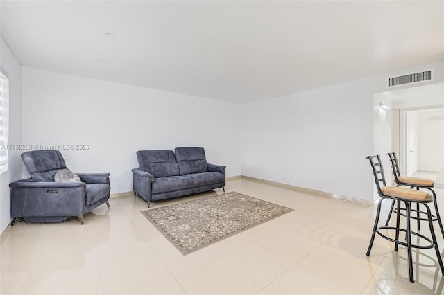 tiled living area featuring visible vents and baseboards