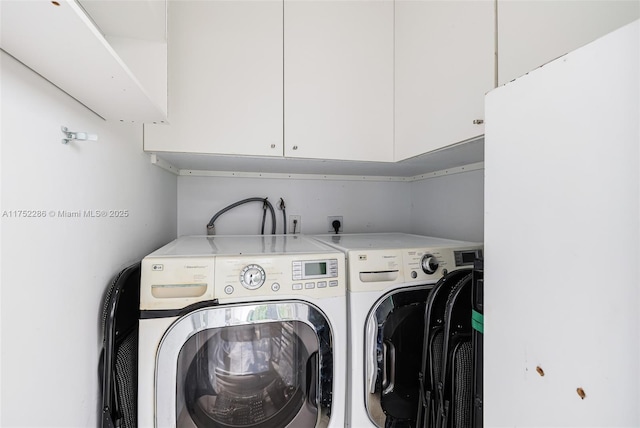 laundry room with washer and clothes dryer and cabinet space