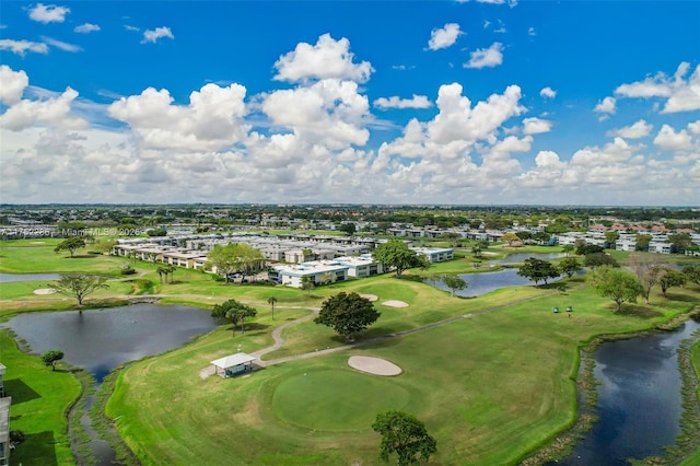 drone / aerial view with view of golf course and a water view