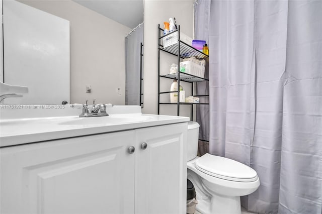 bathroom with toilet, curtained shower, and vanity