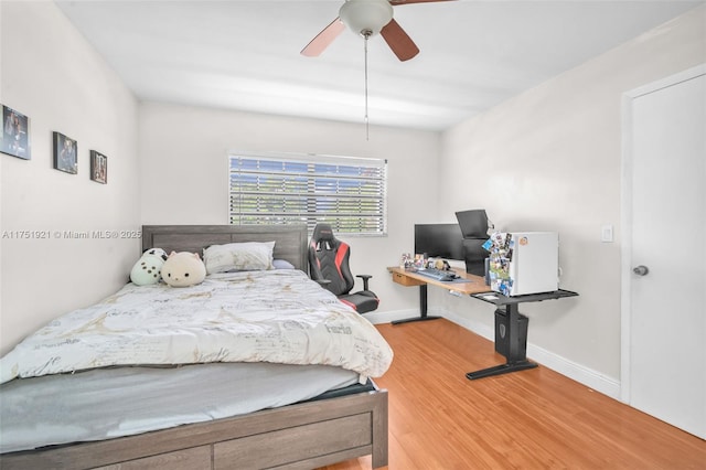 bedroom featuring ceiling fan, baseboards, and wood finished floors