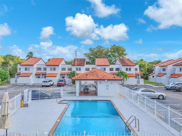 community pool featuring a gazebo, a residential view, fence, and a patio