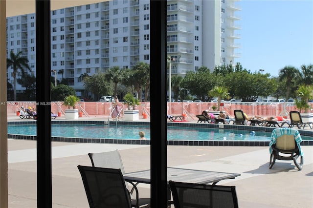 view of swimming pool featuring a patio and fence