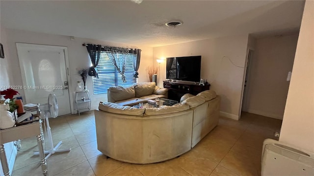 living area with light tile patterned floors, baseboards, and visible vents