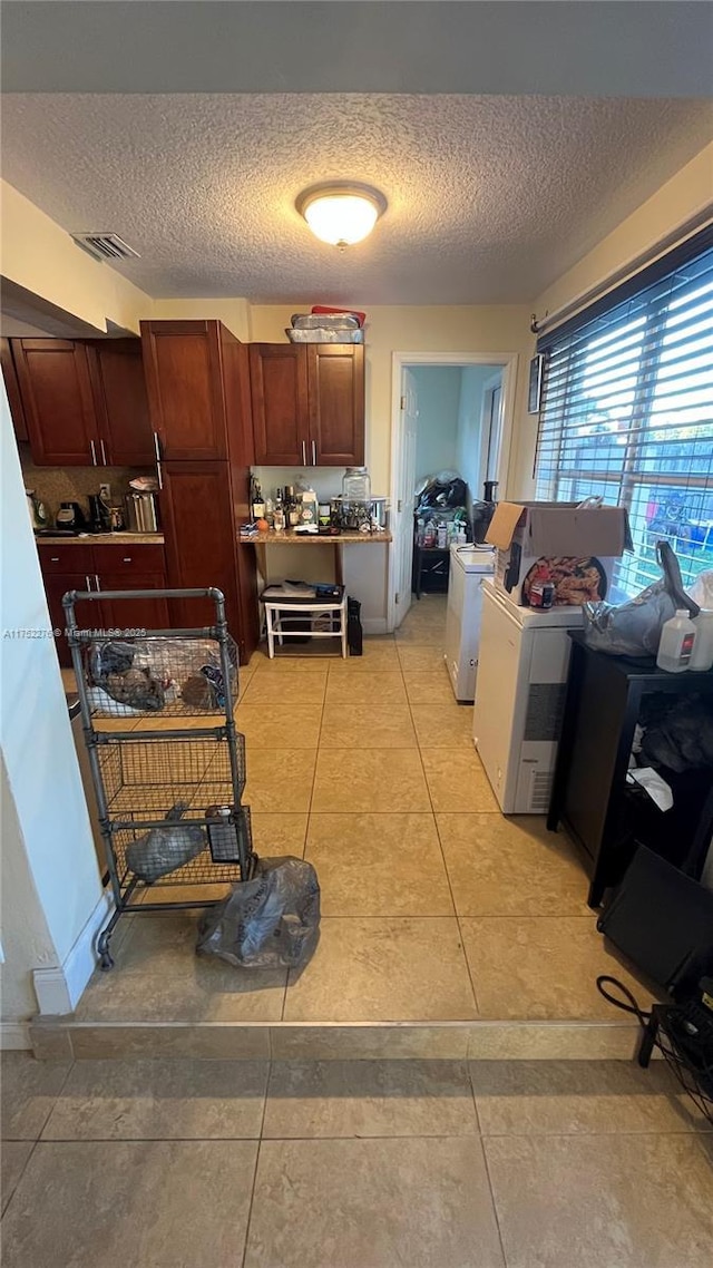 kitchen featuring visible vents, a textured ceiling, and light tile patterned floors