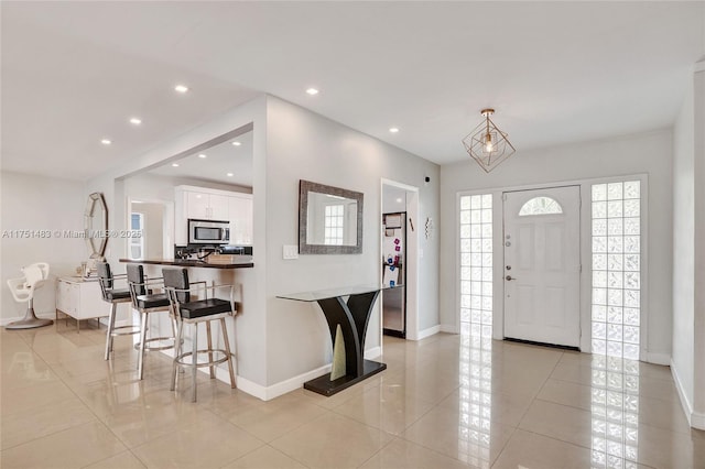 foyer entrance with recessed lighting, baseboards, and light tile patterned floors