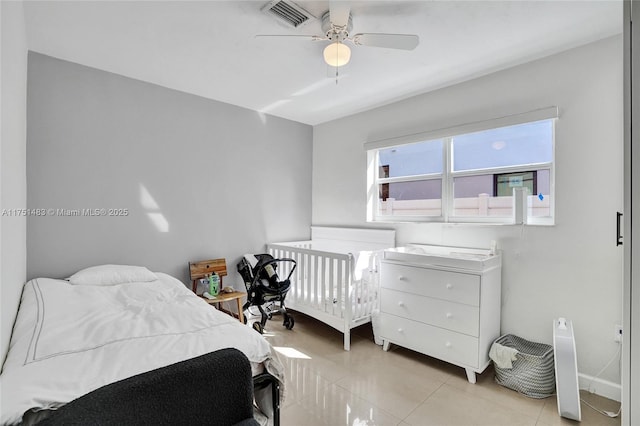 bedroom featuring light tile patterned floors, baseboards, visible vents, and a ceiling fan