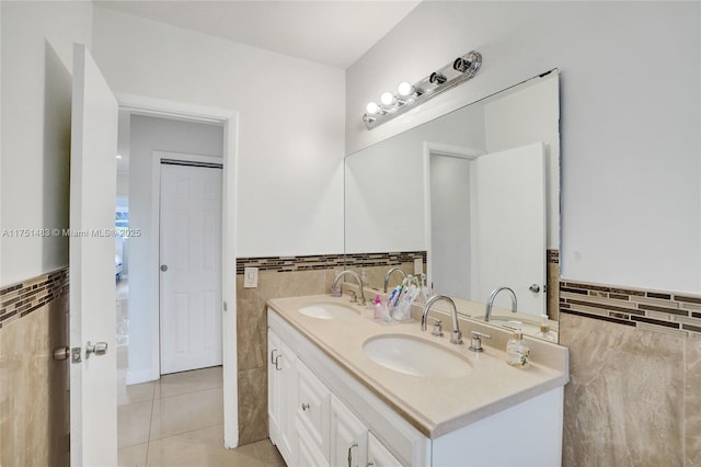 bathroom featuring double vanity, tile patterned flooring, tile walls, and a sink