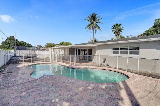 view of pool featuring a trampoline, fence, and a fenced in pool