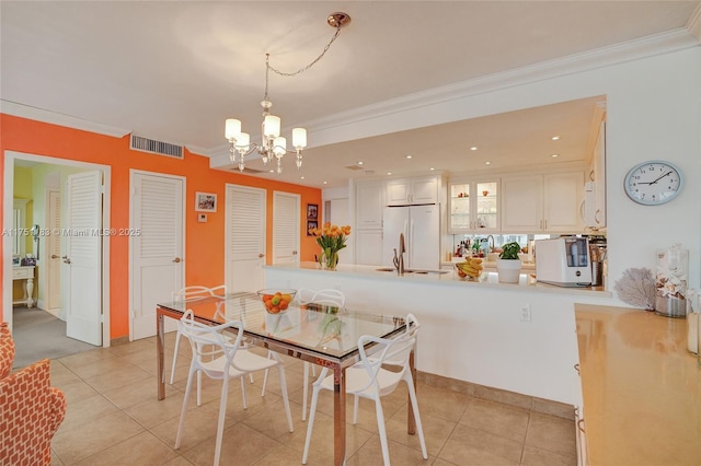 dining room featuring ornamental molding, light tile patterned flooring, visible vents, and an inviting chandelier