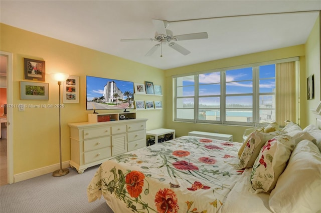 bedroom with a ceiling fan, light colored carpet, and baseboards