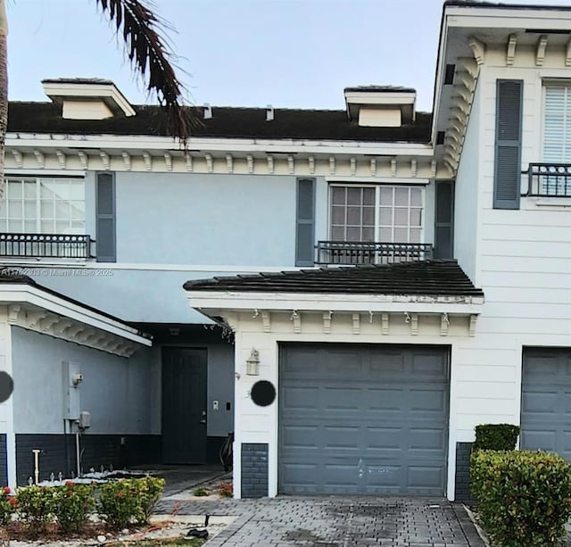 view of front of property featuring decorative driveway and a garage