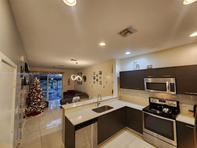 kitchen with light tile patterned floors, visible vents, a sink, stainless steel appliances, and open floor plan