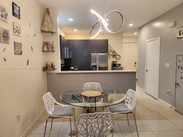 dining space with light tile patterned floors, baseboards, recessed lighting, and a notable chandelier