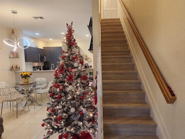 staircase with tile patterned flooring, visible vents, and recessed lighting