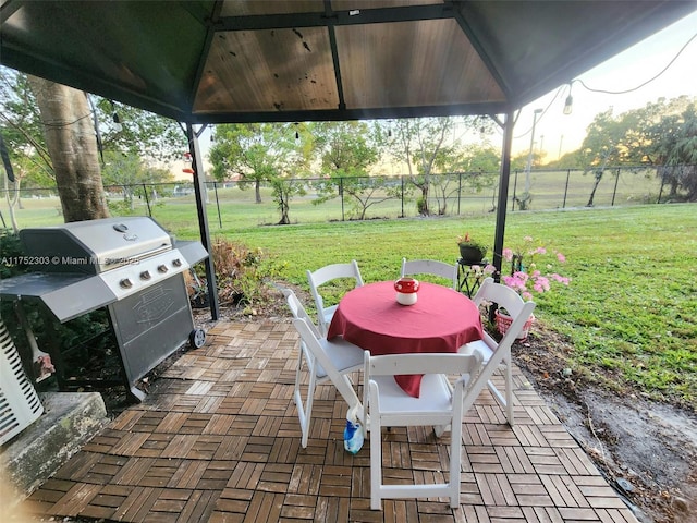 view of patio featuring a gazebo, fence, and a grill