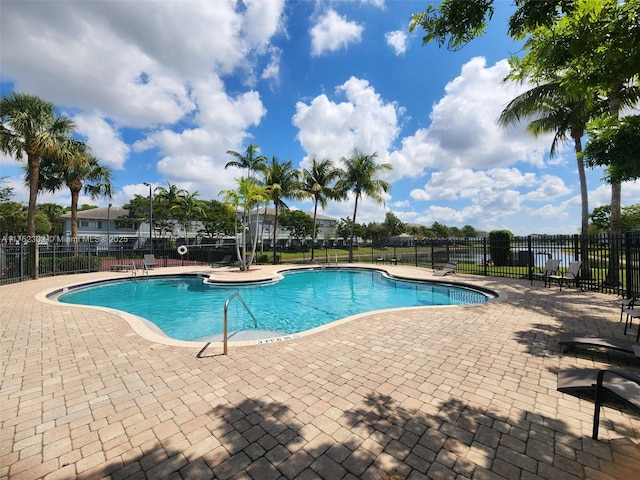 community pool featuring fence and a patio