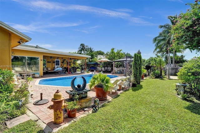 pool with a lawn, a patio, ceiling fan, fence, and a gazebo