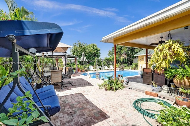 pool with a patio, ceiling fan, fence, a gazebo, and outdoor dining space