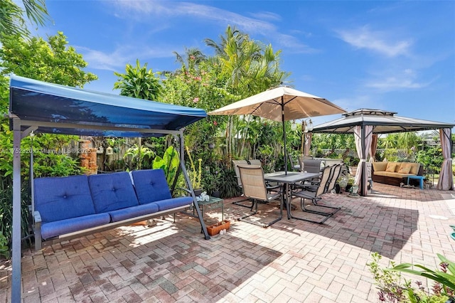 view of patio featuring an outdoor hangout area, a gazebo, outdoor dining area, and fence