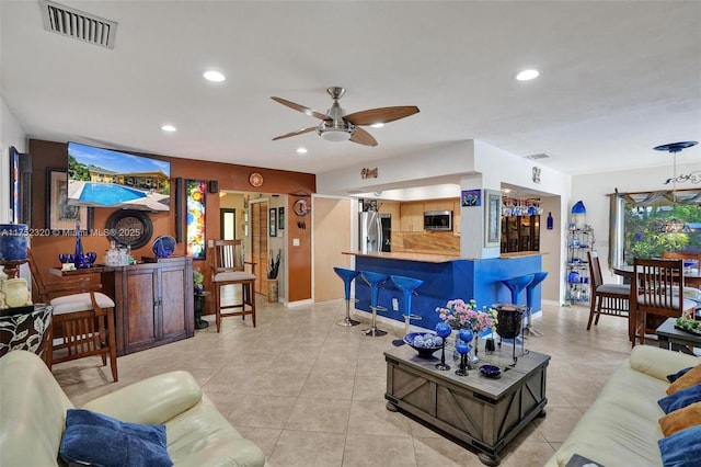 living area featuring light tile patterned floors, a bar, visible vents, and recessed lighting