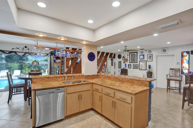 kitchen featuring light tile patterned floors, visible vents, dishwasher, light brown cabinetry, and a sink