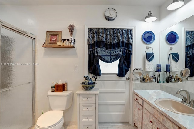 bathroom featuring toilet, a closet, a shower stall, and vanity