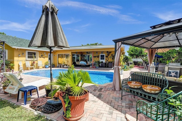 pool with ceiling fan, a gazebo, and a patio area