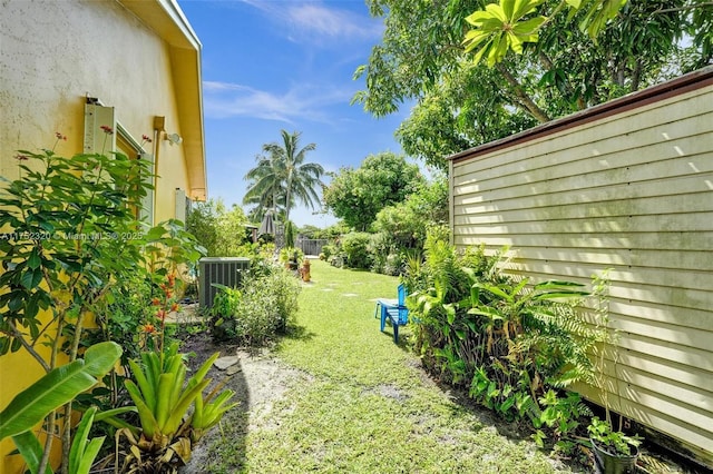 view of yard featuring central AC and fence