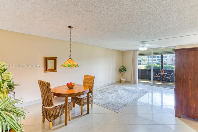 dining area with ceiling fan, a textured ceiling, baseboards, and light tile patterned floors