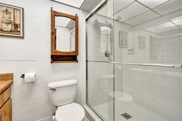 bathroom featuring a stall shower, a textured wall, and vanity