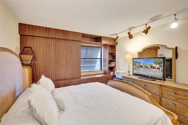 bedroom featuring wooden walls and a textured ceiling