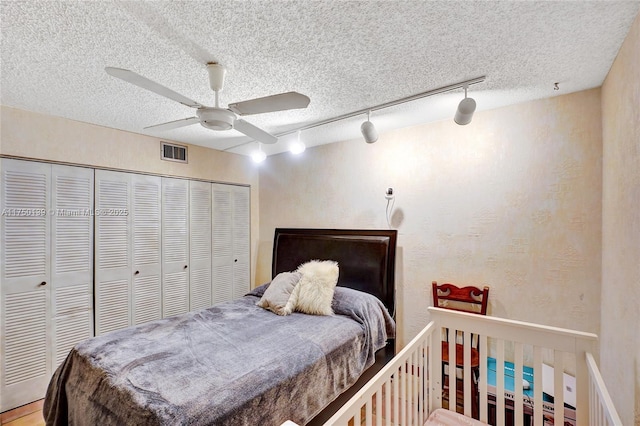 bedroom with a ceiling fan, a closet, visible vents, and a textured ceiling