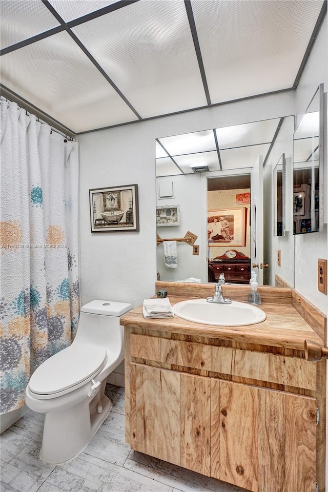 ensuite bathroom featuring connected bathroom, vanity, and toilet