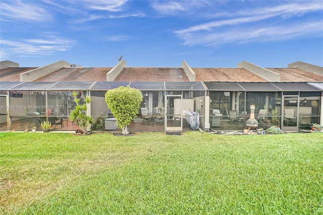 back of house featuring a lanai, a patio area, and a lawn