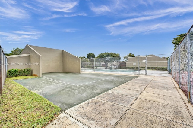 exterior space featuring a tennis court and fence