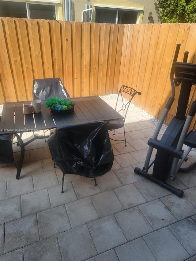 view of patio featuring outdoor dining area and fence