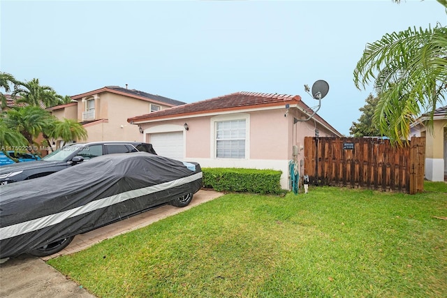 view of property exterior featuring a garage, a yard, fence, and stucco siding