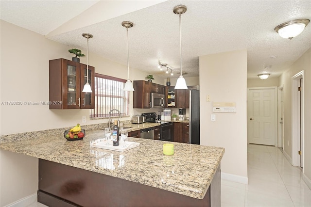 kitchen with a peninsula, glass insert cabinets, stainless steel appliances, and hanging light fixtures