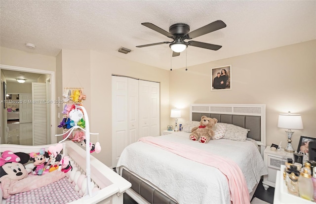 bedroom with a ceiling fan, a textured ceiling, visible vents, and a closet