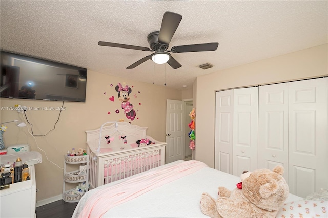 bedroom featuring visible vents, ceiling fan, dark wood-type flooring, a textured ceiling, and a closet