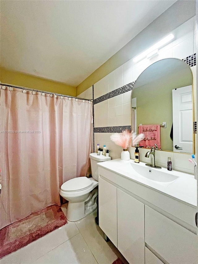 bathroom featuring a shower with shower curtain, toilet, tile patterned floors, vanity, and tile walls