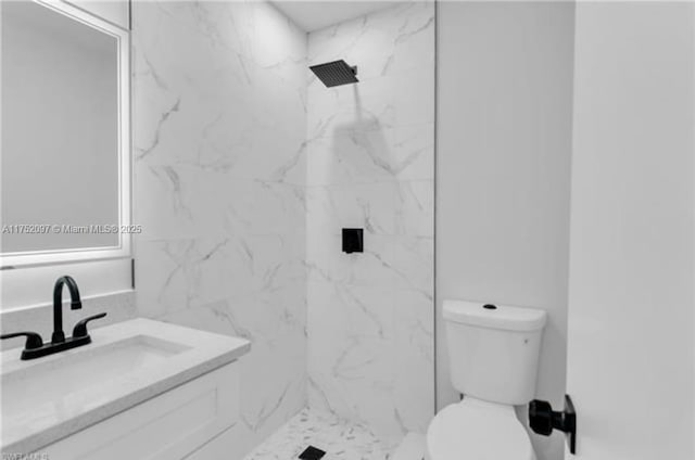 full bath with vanity, a marble finish shower, and toilet