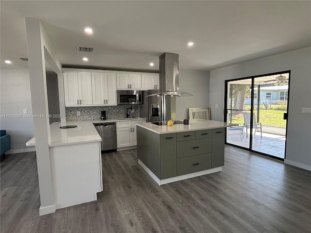 kitchen featuring stainless steel appliances, a kitchen island, white cabinets, backsplash, and island exhaust hood