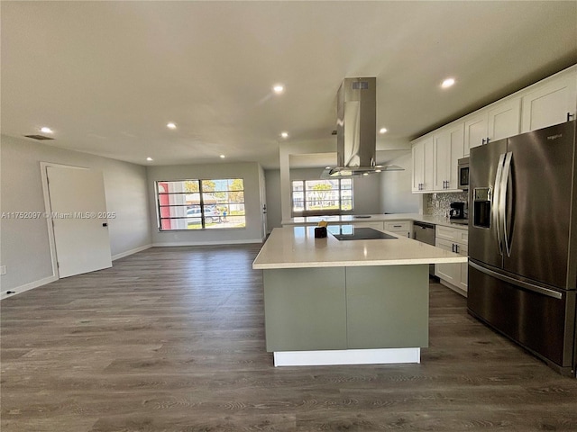 kitchen featuring white cabinets, open floor plan, a center island, island exhaust hood, and stainless steel appliances