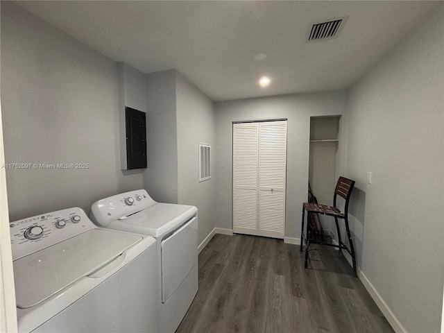 laundry area with electric panel, visible vents, dark wood finished floors, and washer and dryer